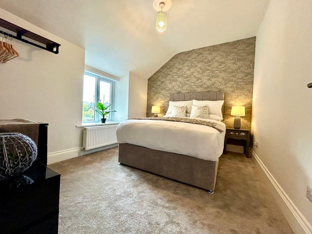 Bright double bedroom with bedside lighting at Sweet Cottage